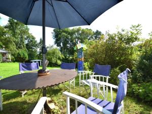 a table and chairs with an umbrella in a yard at Cosy holiday home with gazebo in Weißenburg in Bayern