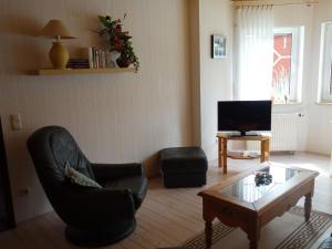 a living room with a chair and a coffee table at Apartment with private terrace in Runkel in Ennerich