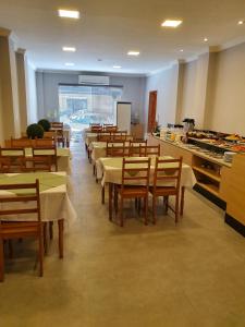 a dining room with tables and chairs in a restaurant at Guaratur Hotel in Linhares