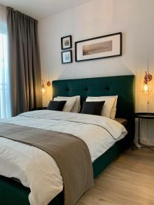 una camera con un grande letto con testiera verde di Modern Studio Coresi a Braşov