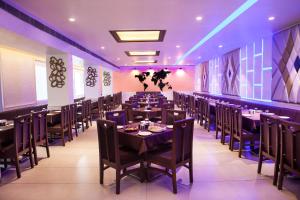 a dining room with tables and chairs and purple lighting at Hotel Fun City in Navsāri