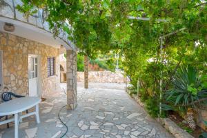 a patio with a table and a stone walkway at Silver Beach Apartments Vis in Vis