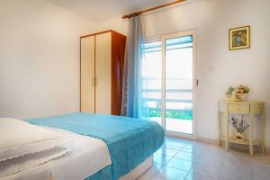 a bedroom with a bed and a large window at Silver Beach Apartments Vis in Vis