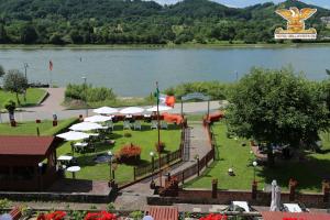 park ze stołami i parasolami przy jeziorze w obiekcie Rheinhotel Bellavista w mieście Braubach