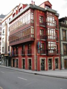 ein rotes Gebäude auf der Straßenseite in der Unterkunft Hotel Vetusta in Oviedo