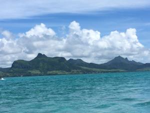 a view of the ocean with mountains in the background at Le Serin Villa in Flic-en-Flac