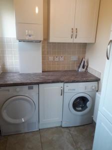 a kitchen with a washing machine and a washer at Aunt Mollie's Cottage in Coalisland