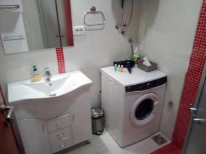 a bathroom with a washing machine and a sink at Apartman Centar 2 in Užice +16 photos