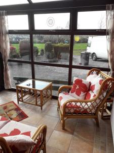 een woonkamer met 2 stoelen en een raam bij Aunt Mollie's Cottage in Coalisland