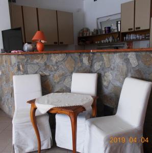 a table and two chairs with a table and a counter at Thelena Apartman in Tolna