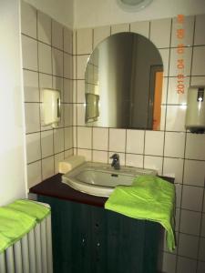 a bathroom with a sink and a mirror at Thelena Apartman in Tolna