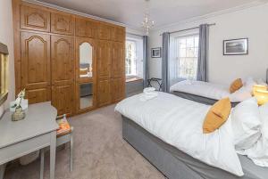 a bedroom with two beds and a desk in it at Maxwelston Farmhouse in Girvan
