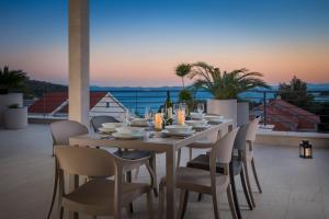 Luxury Villa Lucice View في ميلنا: طاولة طعام وكراسي على شرفة مطلة