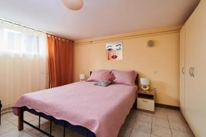 a bedroom with a bed with pink sheets and a window at Apartment Ante in Umag