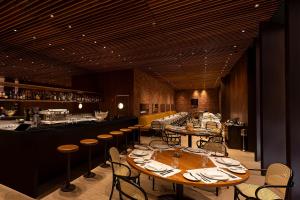 un restaurant avec des tables et des chaises ainsi qu'un bar dans l'établissement Hotel Fasano Belo Horizonte, à Belo Horizonte