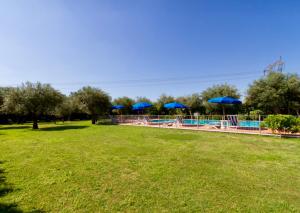 a swimming pool with blue umbrellas in a park at Suite Agave in Seravezza