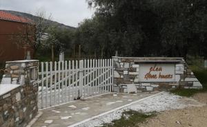 a white fence with a sign that says slow time houses at Elea Stone Houses in organic quiet olive grove, Prinos, Thassos in Prinos
