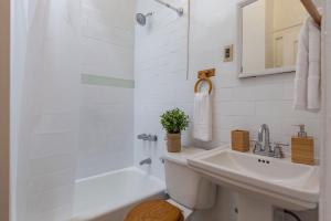 a white bathroom with a sink and a shower at Lavish 3 Bedroom Apt in Williamsburg!! in Brooklyn