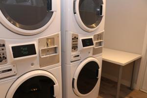 two washing machines are next to each other at A Stylish Stay w/ a Queen Bed, Heated Floors.. #37 in Brookline