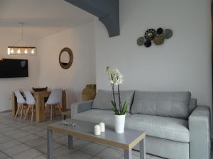 a living room with a couch and a table with flowers at Santoriviera house in Fira