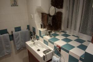 a bathroom with a white sink and blue and white tiles at Palheiro da Assomada in Faja Grande