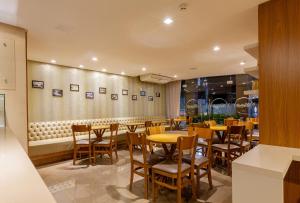 a dining room with wooden tables and chairs at Tri Hotel Executive Brusque in Brusque