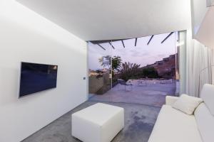 a living room with a white couch and a tv at Casa Cueva Lujo Sacromonte con vistas Alhambra in Granada
