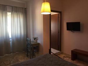 Schlafzimmer mit einem Bett, einem TV und einem Tisch in der Unterkunft La Cannella in Anguillara Sabazia