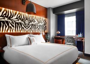 a bedroom with a white bed and a zebra headboard at Hotel Hendricks in New York