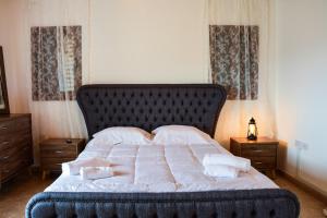 una camera da letto con un grande letto con lenzuola e cuscini bianchi di Aprosmeno Jacuzzi House 1 ad Agros