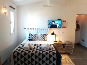a bedroom with a black and white bed with a tv on the wall at Pedras D'el Rei Waterfront Loft in Tavira +36 photos