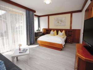 ein Hotelzimmer mit einem Bett und einem TV in der Unterkunft Pension Kathi in Sankt Kanzian am Klopeiner See