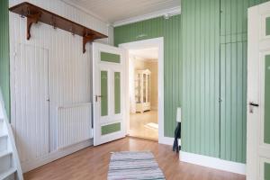 einen Flur mit grünen Wänden und weißen Türen in der Unterkunft Torpet i Sjö in Nyland
