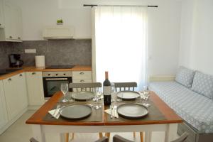 a kitchen with a table with a wine bottle and glasses at Veletas Rooms in Adamantas