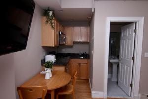 Il comprend une petite cuisine avec une table et des chaises en bois. dans l'établissement Stylish Downtown Studio in the SouthEnd, C.Ave# 2, à Boston