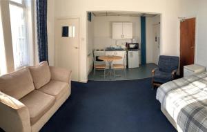 a living room with a couch and a kitchen at Beeton Villas Holiday Apartments in Blackpool