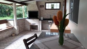 a vase of flowers on a table in a room at Recanto das Saíras in Morretes