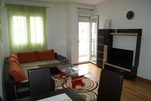 a living room with a couch and a flat screen tv at Oaza apartment in Podgorica