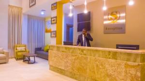 Ein Mann steht hinter einer Rezeption in einer Hotellobby. in der Unterkunft SUNSET HOTEL in Nouakchott + 27 Fotos