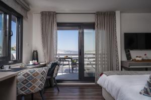 una camera con letto e vista sull'oceano di Urban Nest - Suites & Apartments ad Atene