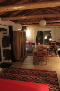 a living room with a table and a dining room at Palheiro da Assomada in Faja Grande