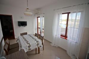 a dining room with a table and chairs and a window at Apartments Simuni 66 in Šimuni