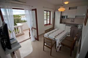 a small kitchen with a table and a view of a balcony at Apartments Simuni 66 in Šimuni