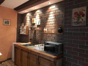 a kitchen with a microwave and a sink and a brick wall at Ganze Unterkunft nur für EUCH! in Rabenau