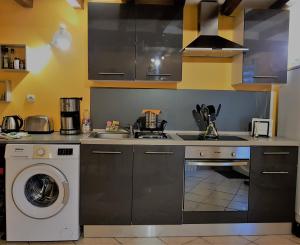 a kitchen with a sink and a washing machine at Le Bleuet in Ouistreham