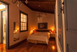 a bedroom with a bed and a mirror at Hotel Solar de Maria in Ouro Preto +66 photos
