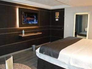 メキシコシティにあるHotel Seoulのベッドルーム1室(ベッド1台、壁にテレビ付)
