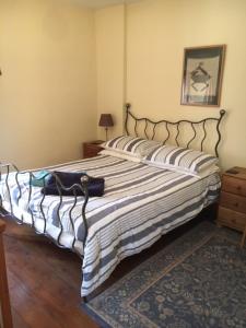 a bedroom with a large bed with a striped blanket at The Forge in Corsham