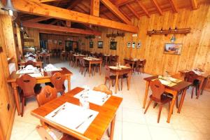 an empty restaurant with wooden tables and chairs at Locanda Lac Place Moulin in Bionaz