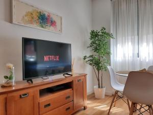 salon z telewizorem w drewnianym centrum rozrywki w obiekcie Sherryflat Moneo - Parking w mieście Jerez de la Frontera